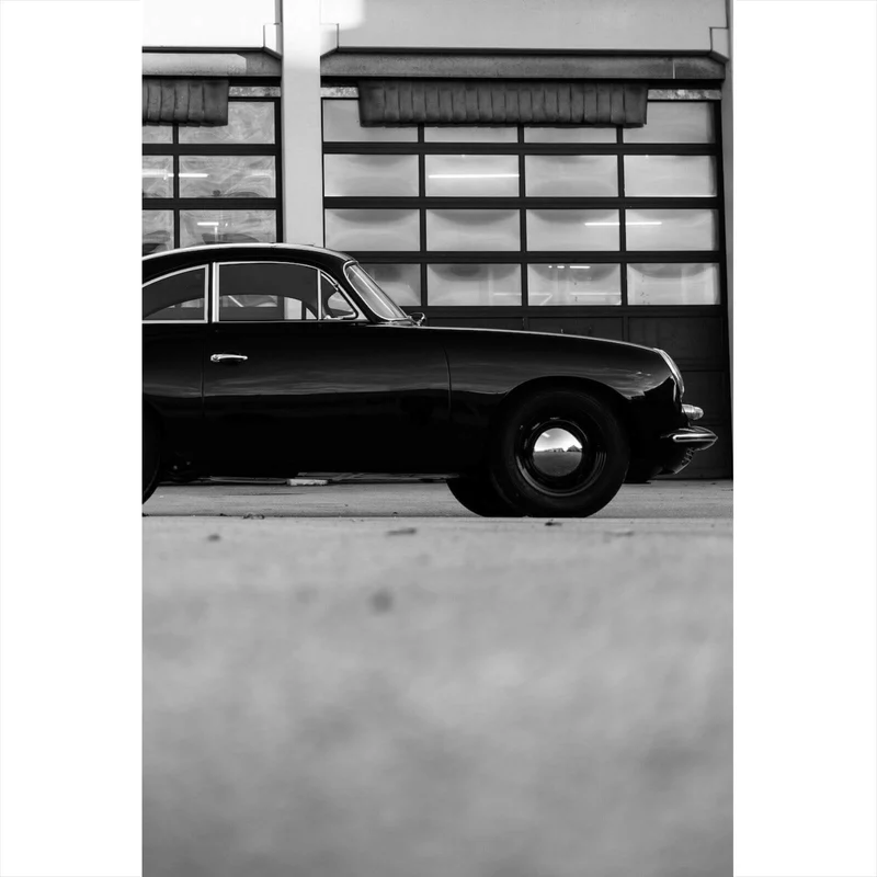 Poster Klassisches Auto vor Werkstattgebäude Hochformat