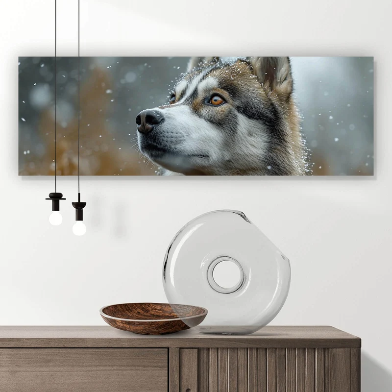 Spannrahmenbild Wolf schaut aufmerksam im winterlichen Schneefall Panorama