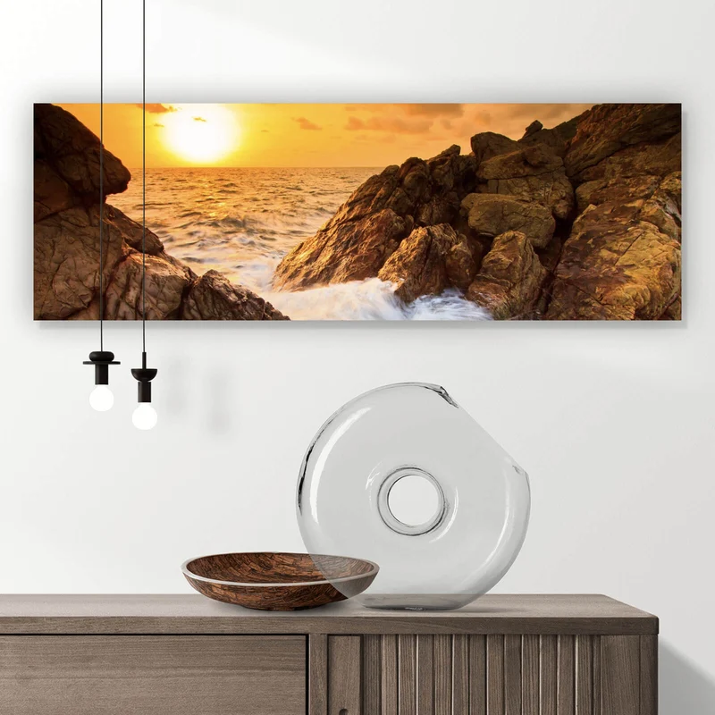 Leinwandbild Sonnenuntergang über felsiger Küstenlandschaft Panorama