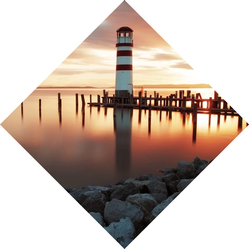 Spannrahmenbild Leuchtturm am Meer in der Abenddämmerung Raute