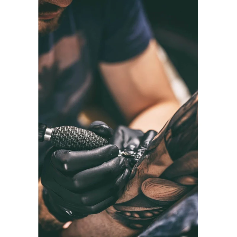 Poster Künstler beim Tätowieren eines Tattoo Hochformat