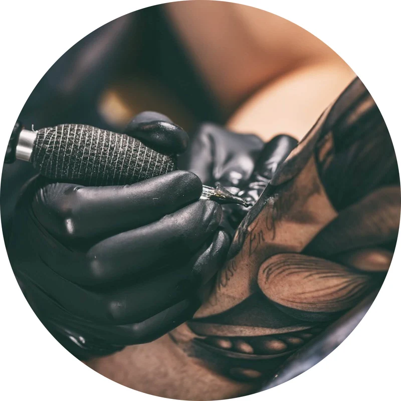 Aluminiumbild gebürstet Künstler beim Tätowieren eines Tattoo Kreis
