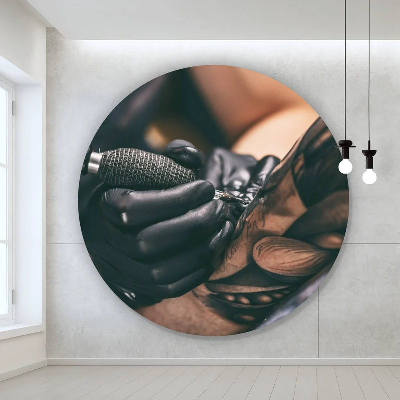 Aluminiumbild Künstler beim Tätowieren eines Tattoo Kreis