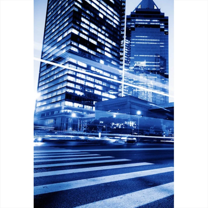Leinwandbild Nachtaufnahme einer Stadtstraße mit Hochhäusern Hochformat